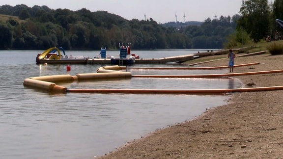 Im Uferbereich des Talsperrensees Malter schwimmen Barrieren im Wasser.