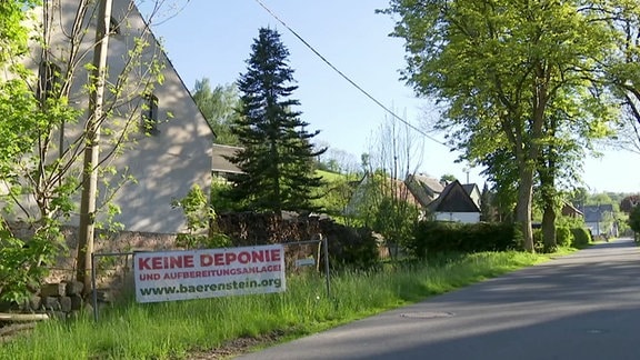 An einem Straßenrand steht ein Schild mit der Aufschrift "Keine Deponie".