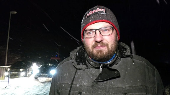 Der Bürgermeister von Altenberg, Markus Wiesenberg, steht mit Mütze im Schneetreiben.