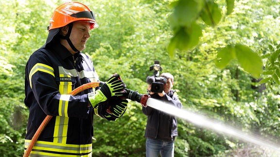 Ein Feuerwehrmann demonstriert während eines Pressetermins zur bevorstehenden Waldbrandsaison in einem Waldstück im Nationalpark Sächsische Schweiz Löschtechnik.