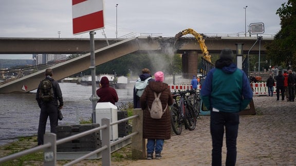 Menschen schauen beim Abriss der Carolabrücke zu.