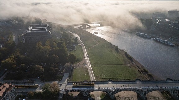 Nebel zieht am Morgen über das Elbtal um die teilweise eingestürzte Carolabrücke, im Vordergrund ist die Augustusbrücke zu sehen.