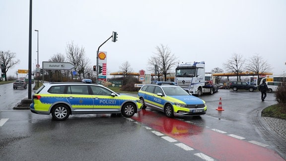 Zwei Polizeiautos blockieren die Einfahrt zu einem Autohof und einer Tankstelle in Dresden-Übigau.