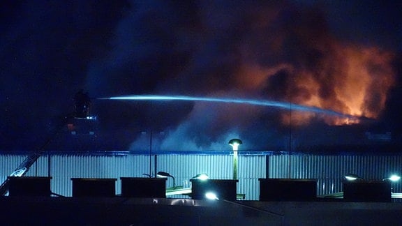 Feuerwehr löscht eine brennende Lagerhalle