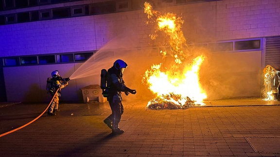 Mit einem Strahlrohr nehmen Einsatzkräfte die Brandbekämpfung auf.