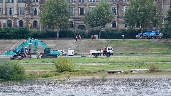 Am Elbufer stehen Bagger und Lkw bereit für Abrissarbeiten.