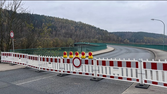 Ein rot-weißer Absperrzaun steht vor der Elbbrücke von Bad Schandau.