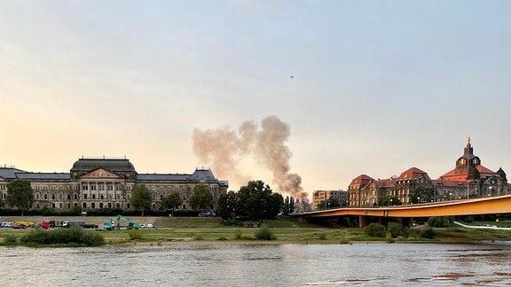 Eine große Rauchwolke über der Elbe zeigt an, dass die Abrissarbeiten begonnen haben.