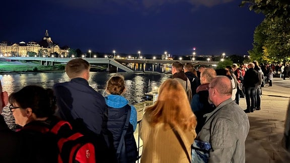 Schaulustige stehen am Abend des 12.9.2024 auf den Brühlschen Terrassen und warten, was mit der Carolabrücke passiert.