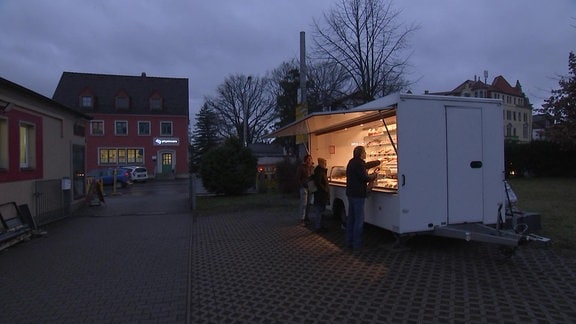 Ein Verkaufswagen vor einem Haus.