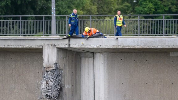 Mitarbeiter vom THW (Technisches Hilfswerk) führen Sicherungsarbeiten durch.