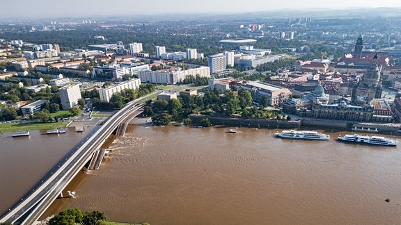 Die Hochwasser führende Elbe fließt an der zum Teil eingestürzten Carolabrücke entlang, im Hintergrund ist die Albertbrücke zu sehen.