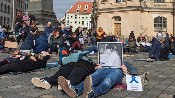 Menschen liegen auf dem Boden vor der Frauenkirche.