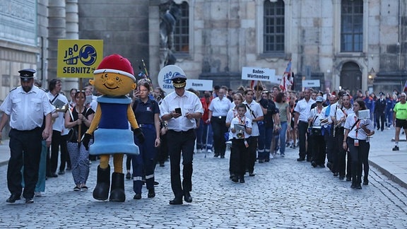 Junge Feuerwehrleute aus ganz Deutsxhland laufen als Festzug in Dresden in die Altstadt ein.