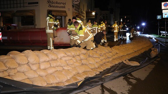 Die Feuerwehr stapelt in Dresden-Laubegast Sandsäcke zum Schutz vor Hochwasser.