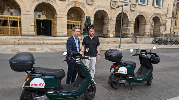 Zwei Männer zwischen zwei E-Mopeds