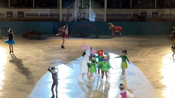 Darstellung eines Märchens durch Personen in Kostümen auf einer Eisfläche.