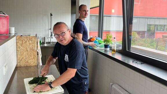 Feuerwehrwache - Zwei Männer arbeiten in der Küche