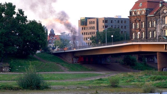 Eine Rauchwolke und Feuer beim Abriss der Carolabrücke