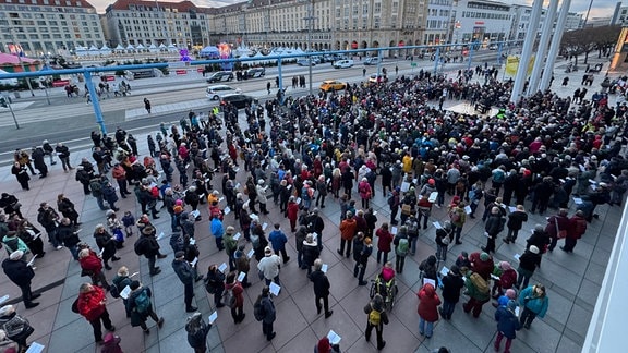 Menschen versammeln sich auf einem Platz in Dresden.