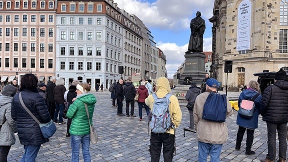 Mehrere Menschen bei einer Demo vor der Frauenkirche in Dresden