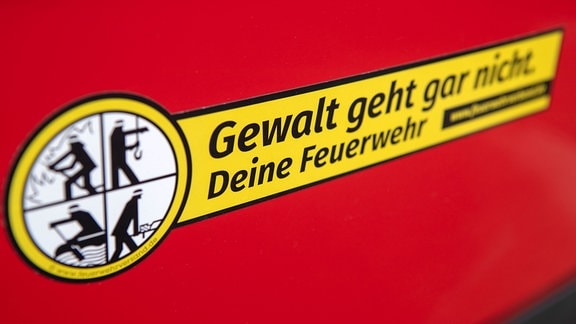 Ein Aufkleber des Feuerwehrverbands mit der Aufschrift "Gewalt geht gar nicht" ist 2019 an einem Feuerwehrauto zu sehen.