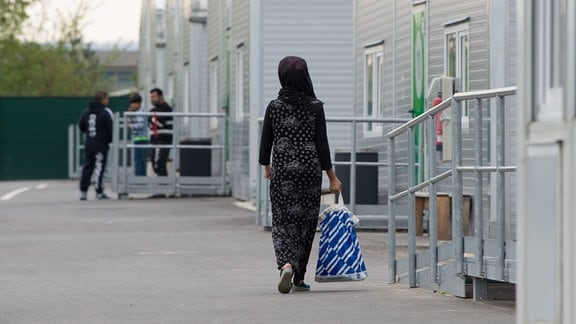 Eine Frau läuft durch eine Erstaufnahmeeinrichtung für Flüchtlinge