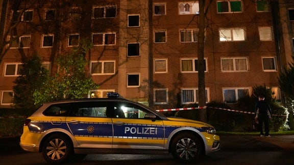 Ein Streifenwagen steht vor einem Wohnblock in Gorbitz.