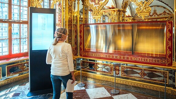 Eine Besucherin schaut in die ausgeraubte und nun ausgestellte Vitrine im Juwelenzimmer des Historischen Grünen Gewölbes im Residenzschloss in Dresden