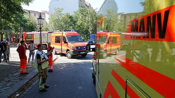 An einer Straßenkreuzung in Dresden stehen Einsatzfahrzeuge woei Mitarbeiter von Feuerwehr und Rettungsdienst