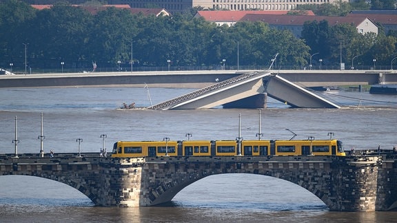 Die Hochwasser führende Elbe fließt an der teileingestürzten Carolabrücke entlang