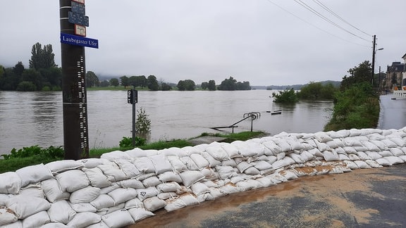 Sandsäcke an einem Fluss.