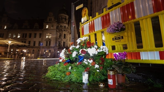 Blumen und Kerzen liegen unweit des Residenzschlosses vor einem Bauzaun an der Schlossstraße. Am Abend des 4. Oktober 2020 waren nahe dem Schloss zwei Touristen Opfer einer Messerattacke geworden.