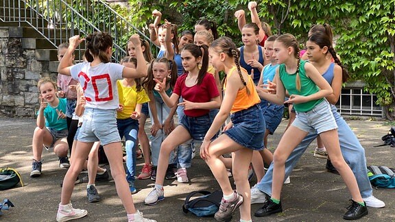 Eine Mädchen-Tanzgruppe des Heinrich-Schütz-Konservatoriums Dresden probt auf einem Hof die Choreografie "Ein Schultag".