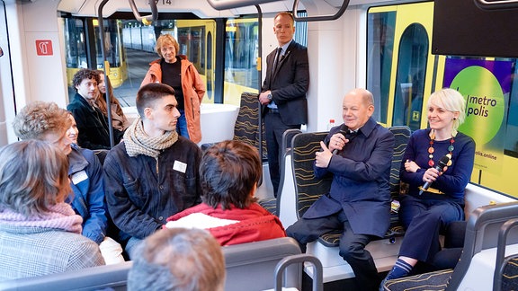 Bundeskanzler Olaf Scholz SPD gemeinsam mit Projektleiterin Kristina Krömer bei der Gesprächsrunden mit bis zu drei Fahrgästen in einer stehenden Strassenbahn auf dem Betriebshof Trachenberge, Dresden.