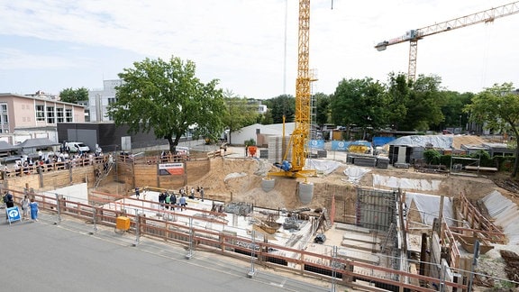 Teilnehmer der Grundsteinlegung eines Neubaus für das Deutsche Krebsforschungszentrums (DKFZ) stehen auf der Baustelle.