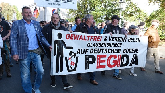 Lutz Bachmann (l), Gründer des islamkritischen Bündnisses Pegida, geht auf einer Demonstration.