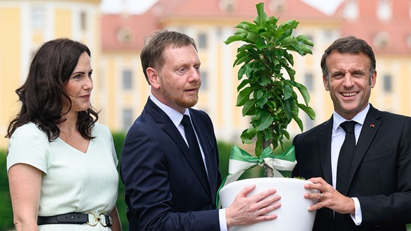 Emmanuel Macron (r), Präsident von Frankreich, Michael Kretschmer (CDU, 2.v.l), Ministerpräsident von Sachsen, und dessen Ehefrau Annett Hofmann (l) stehen vor dem Schloss Moritzburg.