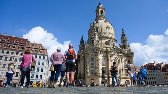 Touristen sind bei sonnigem Wetter in der Altstadt auf dem Neumarkt vor der Frauenkirche unterwegs.