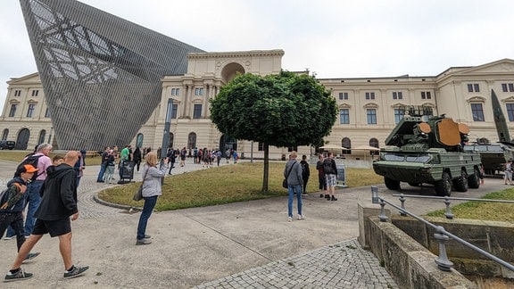 Mehrere Besucher laufen in Richtung Militärhistorischen Museum Dresden. 