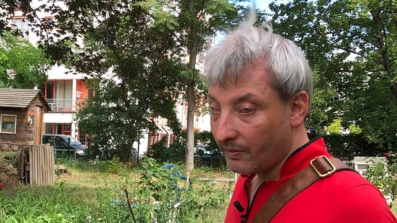 Marco Rademann steht im internationalen Garten an seinem Beet.