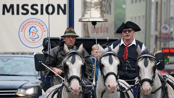 Eine aus Militärschrott gegossene Friedensglocke hängt bei der Auftaktveranstaltung zum «Friedensglocken-Pferdetreck 24 Dresden - Prag - Chemnitz» an einem Mast auf einem Pferdewagen.
