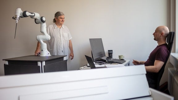 Zwei Männer in einem Büro mit einem Roboterarm