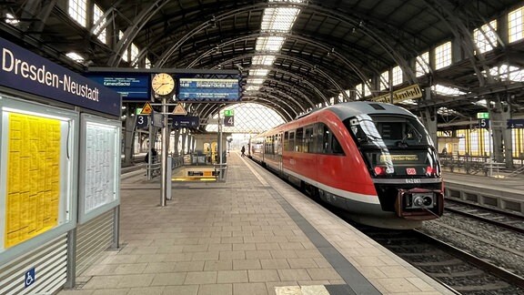 Ein roter Triebwagen der Deutschen Bahn steht als Regionalbahn an einem Bahnsteig im Bahnhof Dresden-Neustadt. 