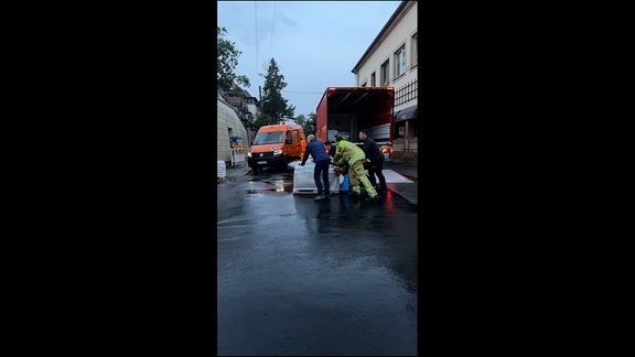 Die Feuerwehr liefert mit einem LKW Sandsäcke an