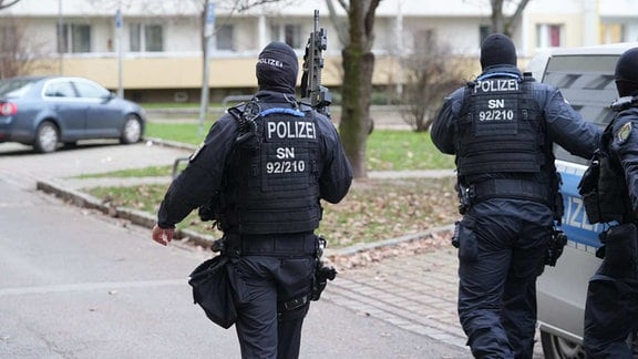 SEK-Einsatz in Dresden; bewaffnete Polizisten gehen durch ein Wohngebiet