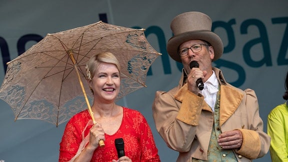 Manuela Schwesig (SPD,l), Ministerpräsidentin von Mecklenburg-Vorpommern und Stefan Fassbinder (Grüne), Oberbürgermeister von Greifswald, stehen auf dem Markt von Greifswald. 