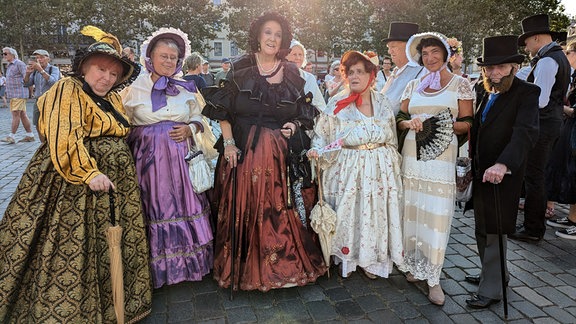 Vier vergnügte Frauen haben sich Mühe gegeben und Kleider im Stil der romantik zusammenzustellen.