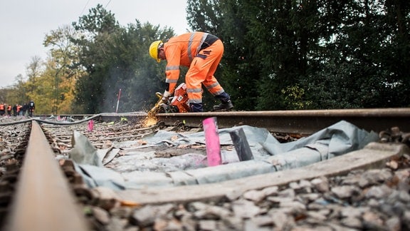 Ein Bauarbeiter der Deutschen Bahn trennt am am Bahnhof Essen-Hügel mit einer Flex eine Schiene durch.