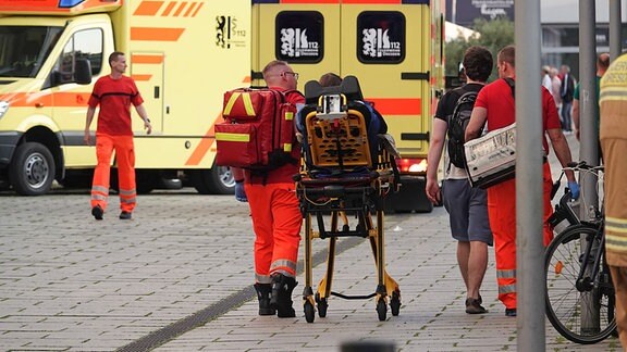 Einsatzkräfze bringen eine Person auf einer Trage zu einem Rettungswagen